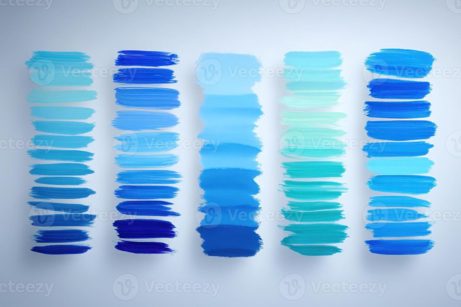 Multiple vertical paint swatches display a gradient of blue hues, ranging from deep navy to soft aqua, showcasing an artistic blend of colors against a light backdrop. photo