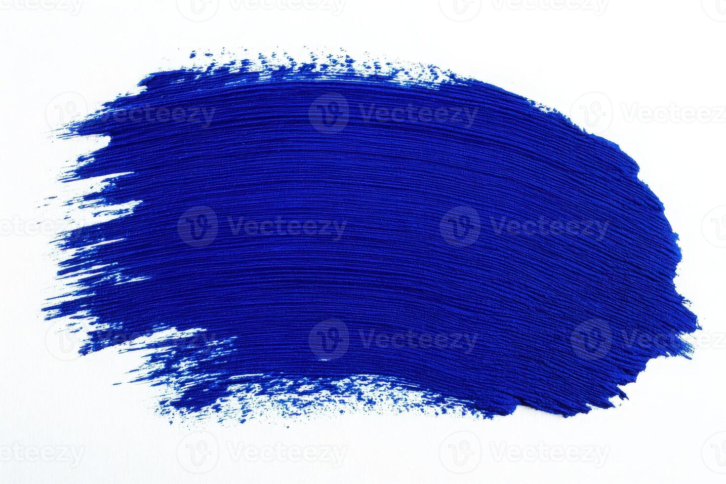 A vivid blue paint stroke is applied smoothly across a stark white canvas, demonstrating the depth and richness of the color. photo
