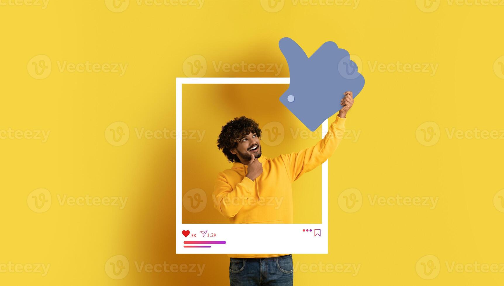 A cheerful influencer dressed in a yellow sweater gives a thumbs up inside a white frame on a bright yellow background, perfect for content creation and engagement on social media platforms. photo