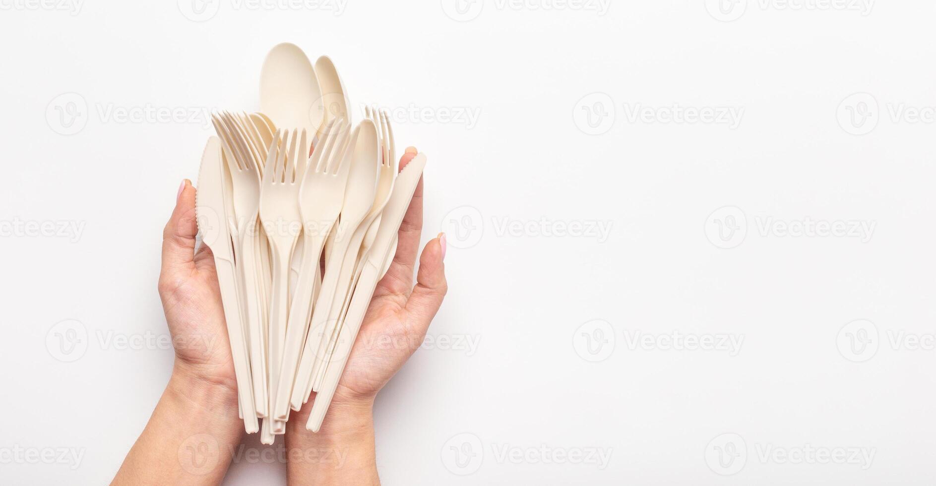Woman holding in hands set of biodegradable single use cutlery of avocado seeds isolated on white background, panorama, copy space photo
