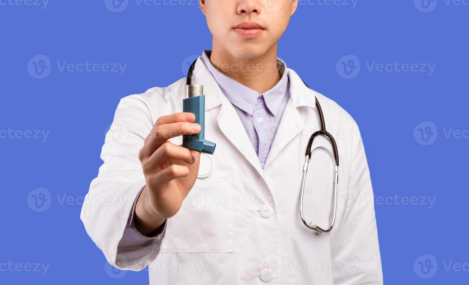 Treatment For Asthma Attacks. Closeup of unrecognizable asian male doctor holding and showing inhaler in hand. Healthcare And Medicine Concept. Medication And Prescription For Lungs Diseases photo