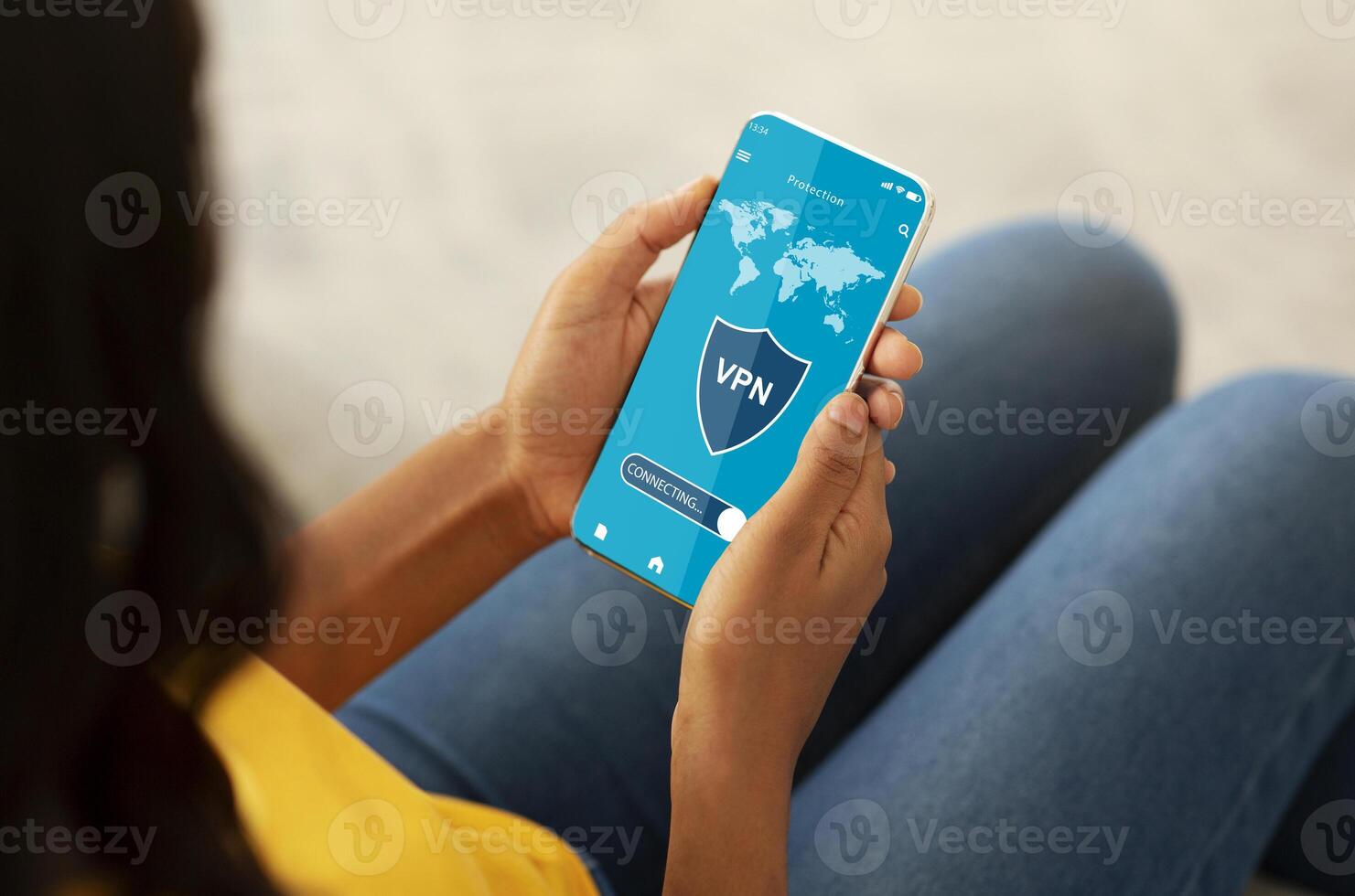 Over The Shoulder View Of African American Woman Using Her Mobile Phone With VPN Virtual Private Network Connection For Secure Traffic, Cyber Security And Personal Data Protection Online photo