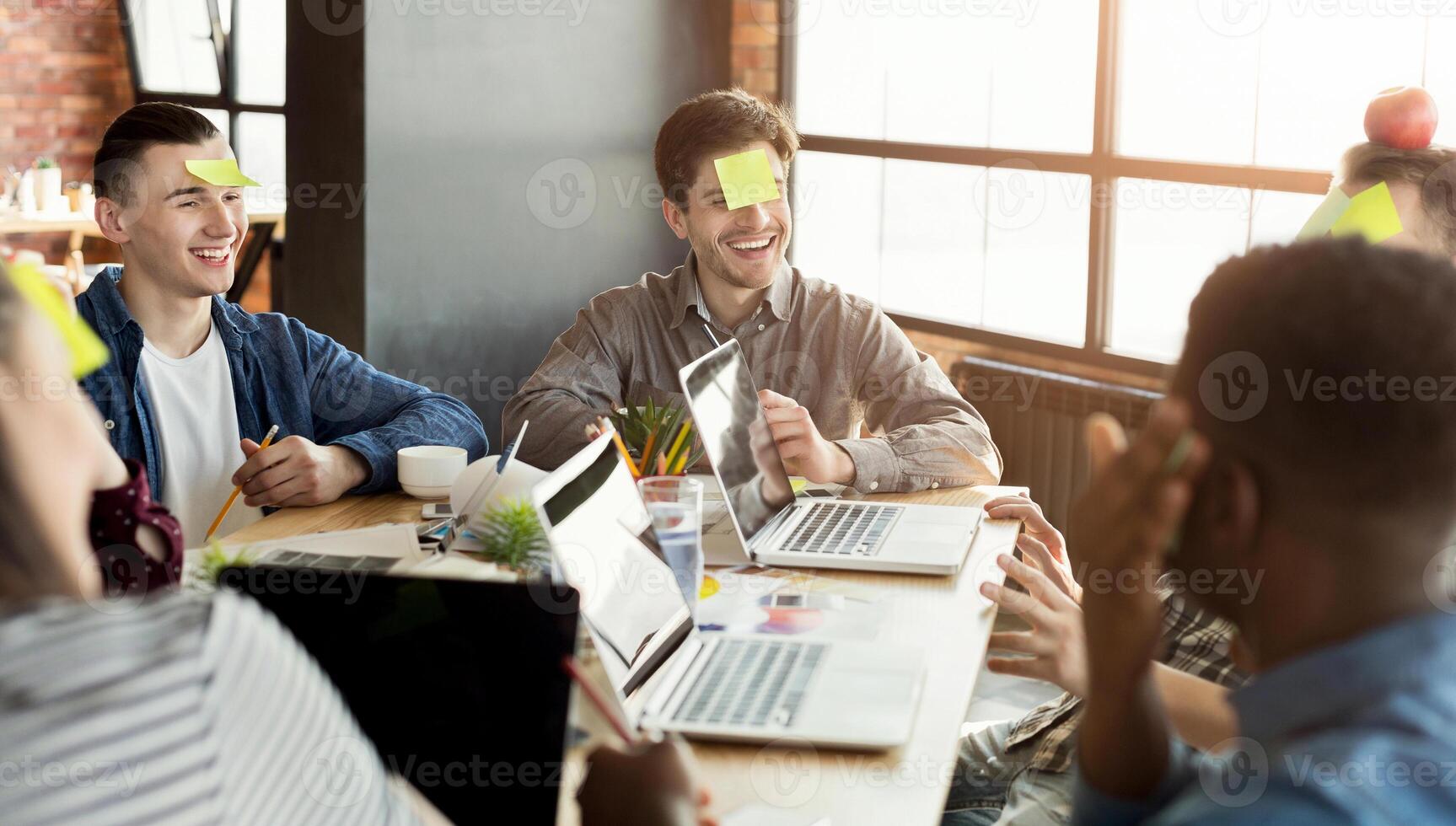 Team building. Happy colleagues playing who I am game, having great pastime together, copy space photo