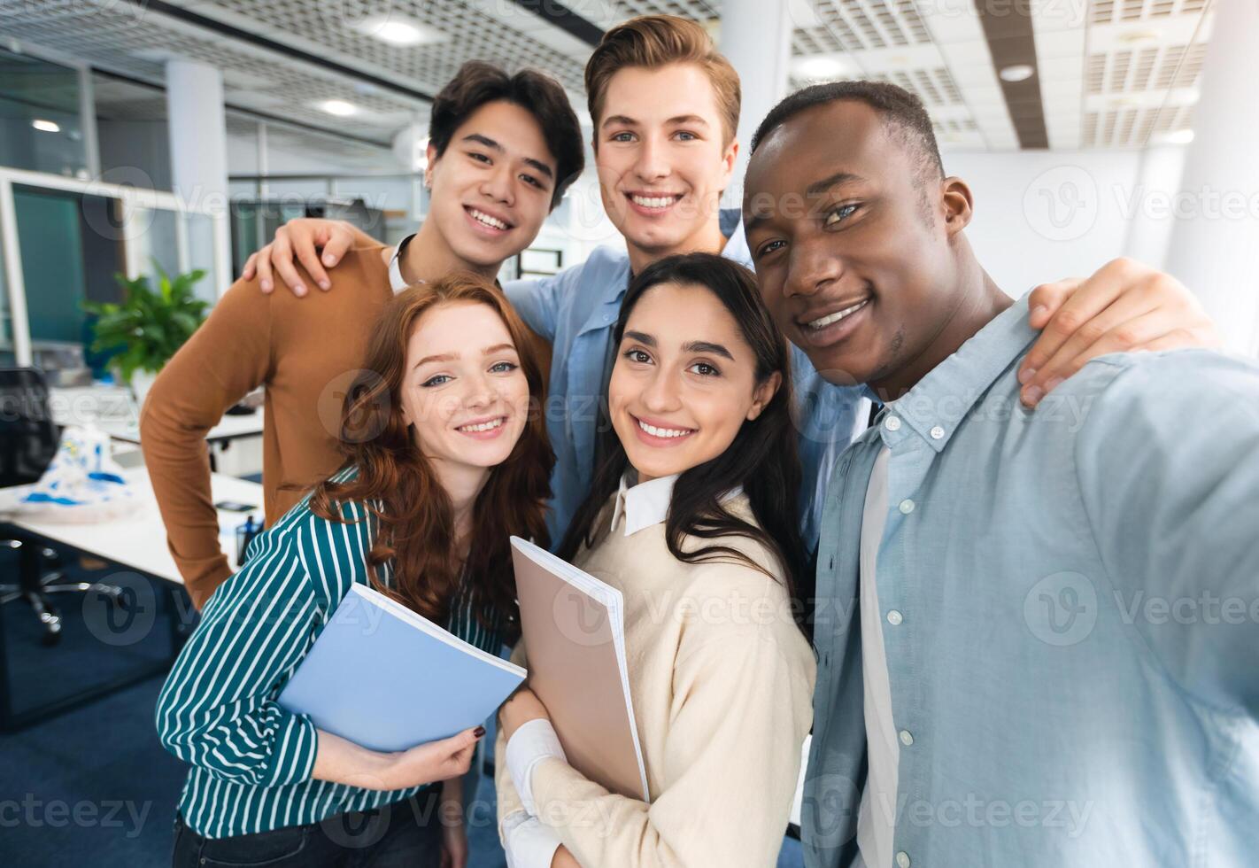 Cheerful Multicultural Students Posing Together Making Selfie In University Lecture Hall Indoors, Having Fun And Looking At Camera, Point Of View. College Friends, High School Education Concept photo