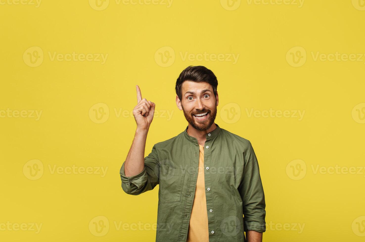 Positive man experiencing AHA moment, having creative idea or pointing finger up at copy space over yellow studio background. Middle aged man gesturing eureka photo