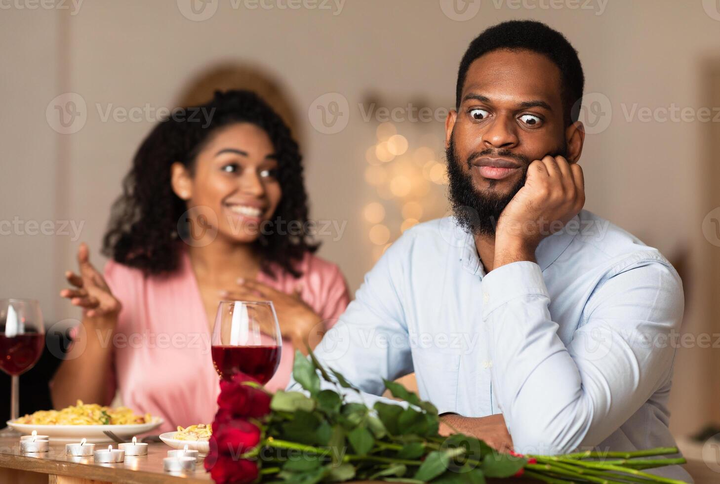 Bad First Impression And Date Concept. Dissatisfied shocked black man listening to excited emotional obsessed woman talking, young couple sitting at table in cafe. Unpleasant conversation photo