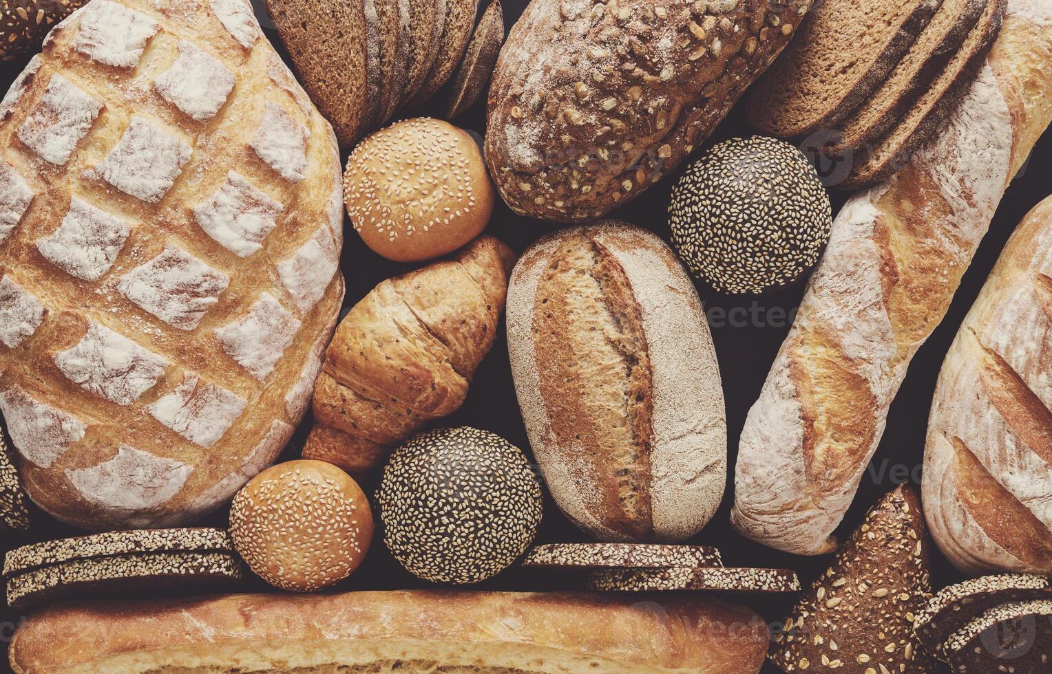 Bread background, top view of white, black and rye loaves on black photo