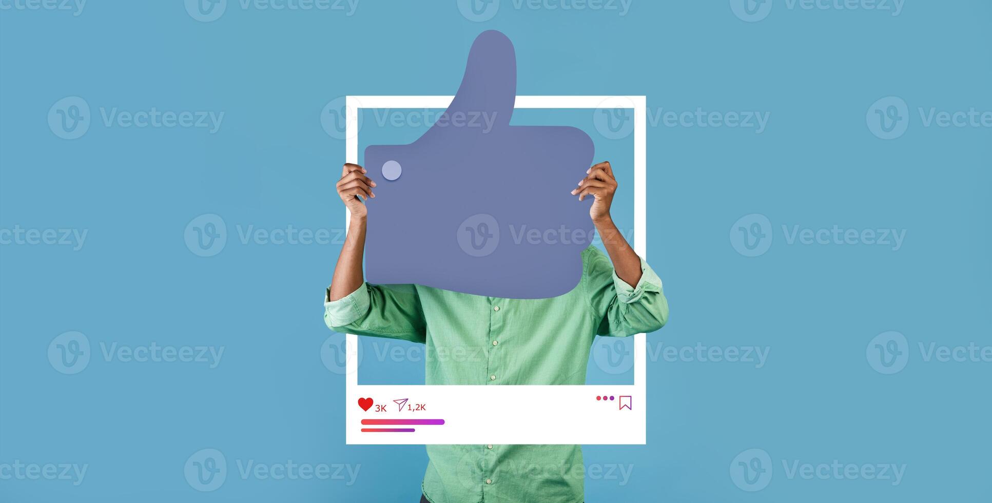A person holds up a large thumbs up sign framed within a social media backdrop, promoting positivity. The blue background enhances the feeling of approval and connection for online influencers. photo
