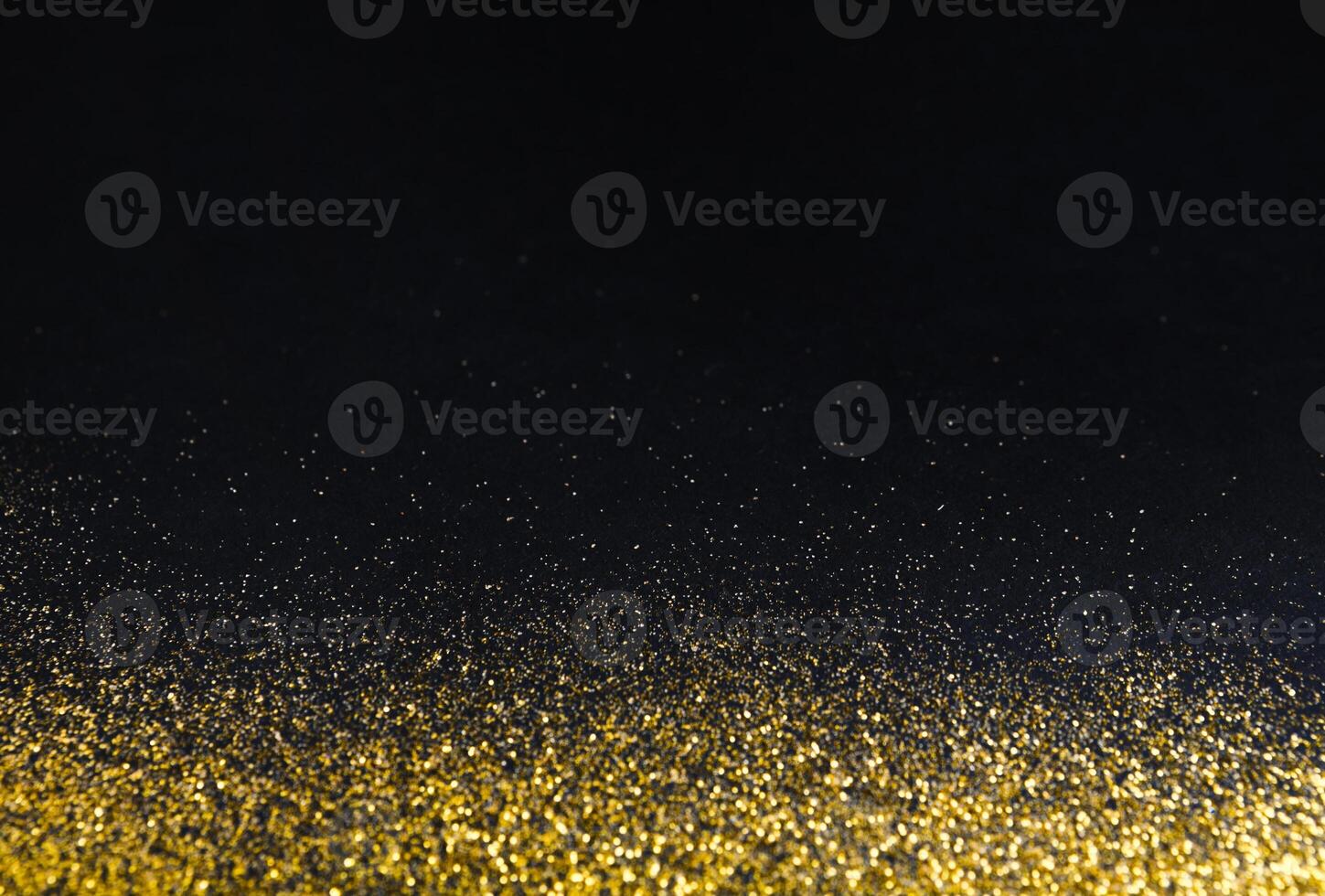 Golden glitter sand texture border on black, abstract background with copy space. Yellow dusty shimmer decoration, shiny and sparkling. Holidays and glamour concept. photo