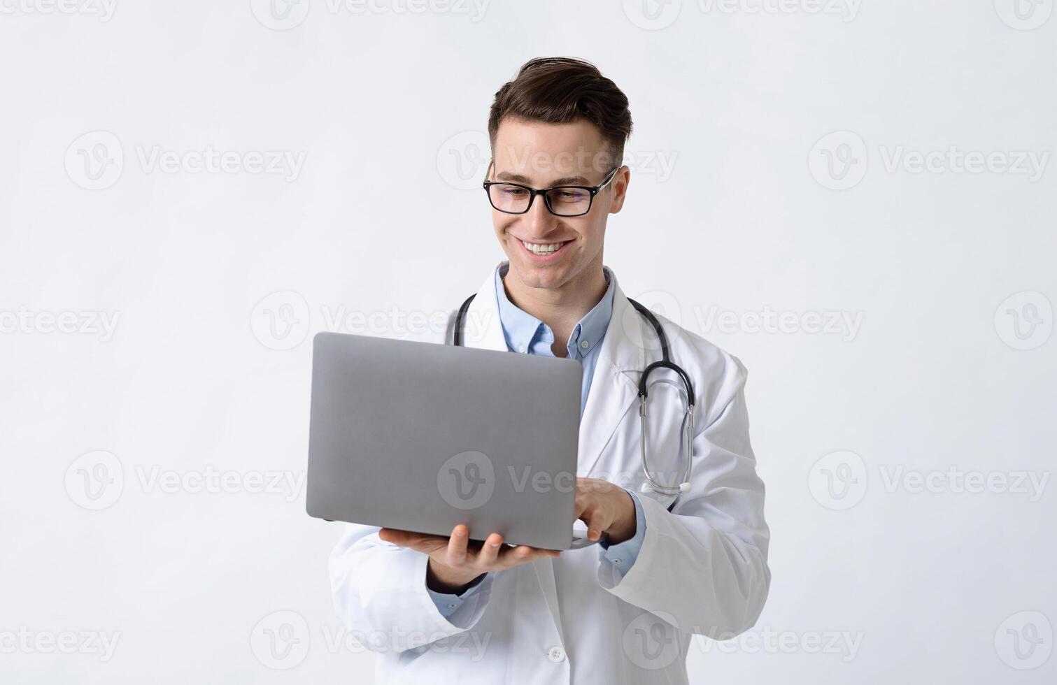 Smiling doctor in glasses and laptop in hands on white background photo