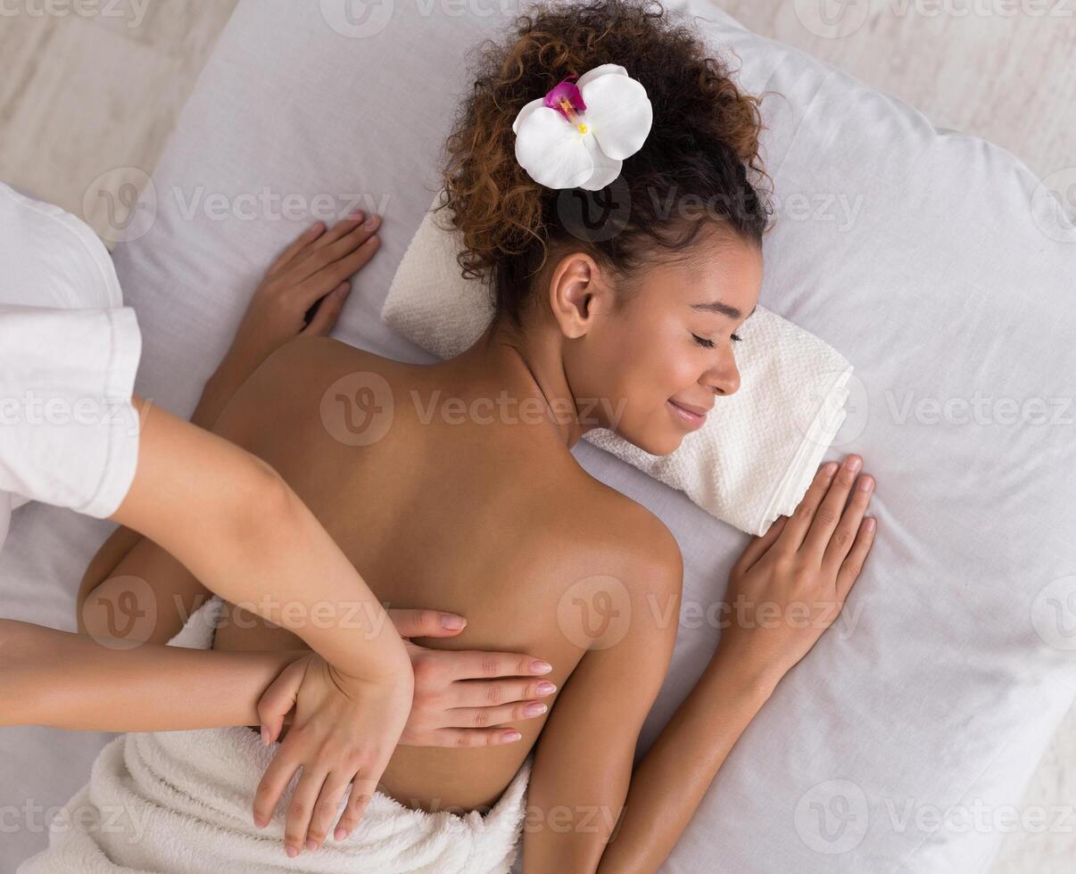 Woman relaxing and having back massage in spa salon, top view photo