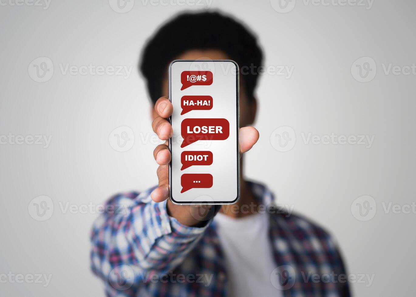 Cyberbullying concept. African American guy showing smartphone with abusive messages on screen, grey background. Collage photo