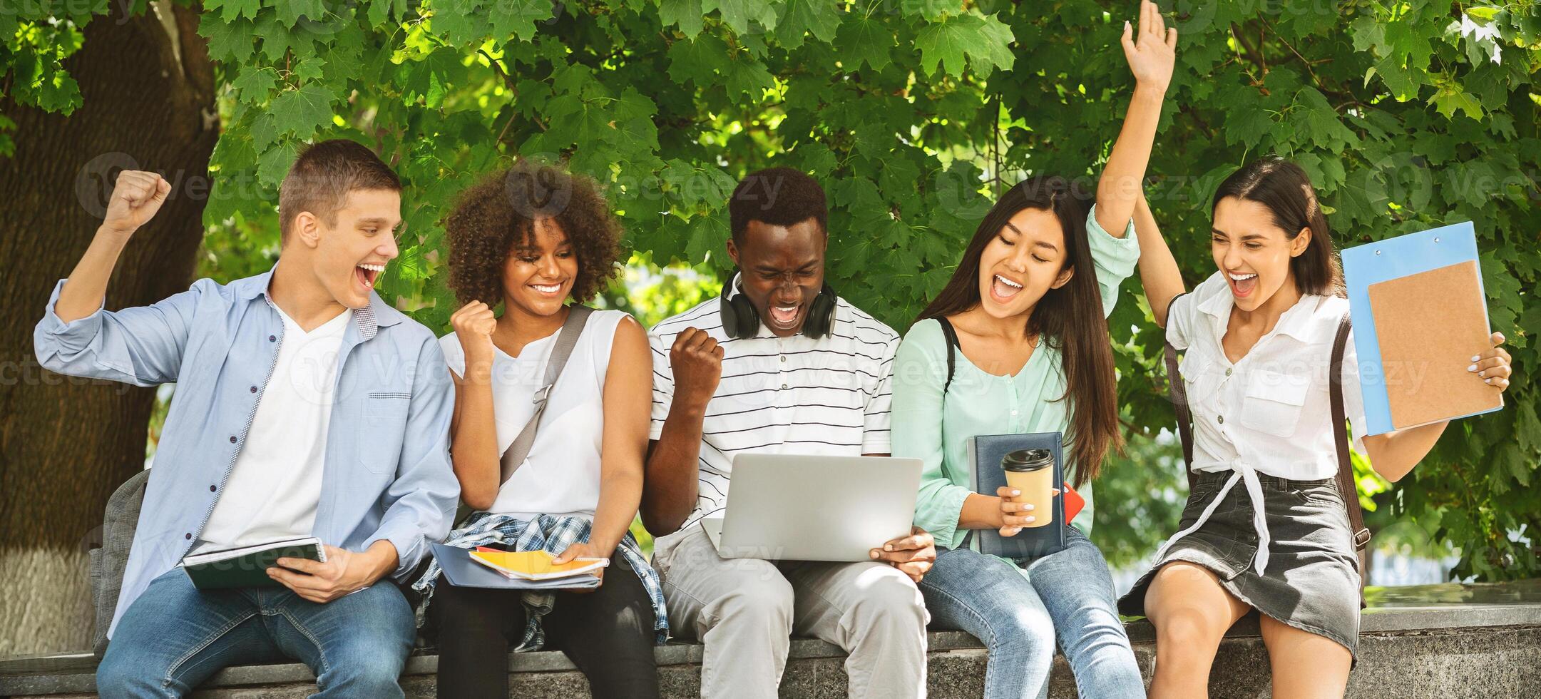 Accepted Students. Joyful Multicultural Teens Celebrating Success With Laptop Outdoors, Cheering Successful Exam Pass, Panorama photo