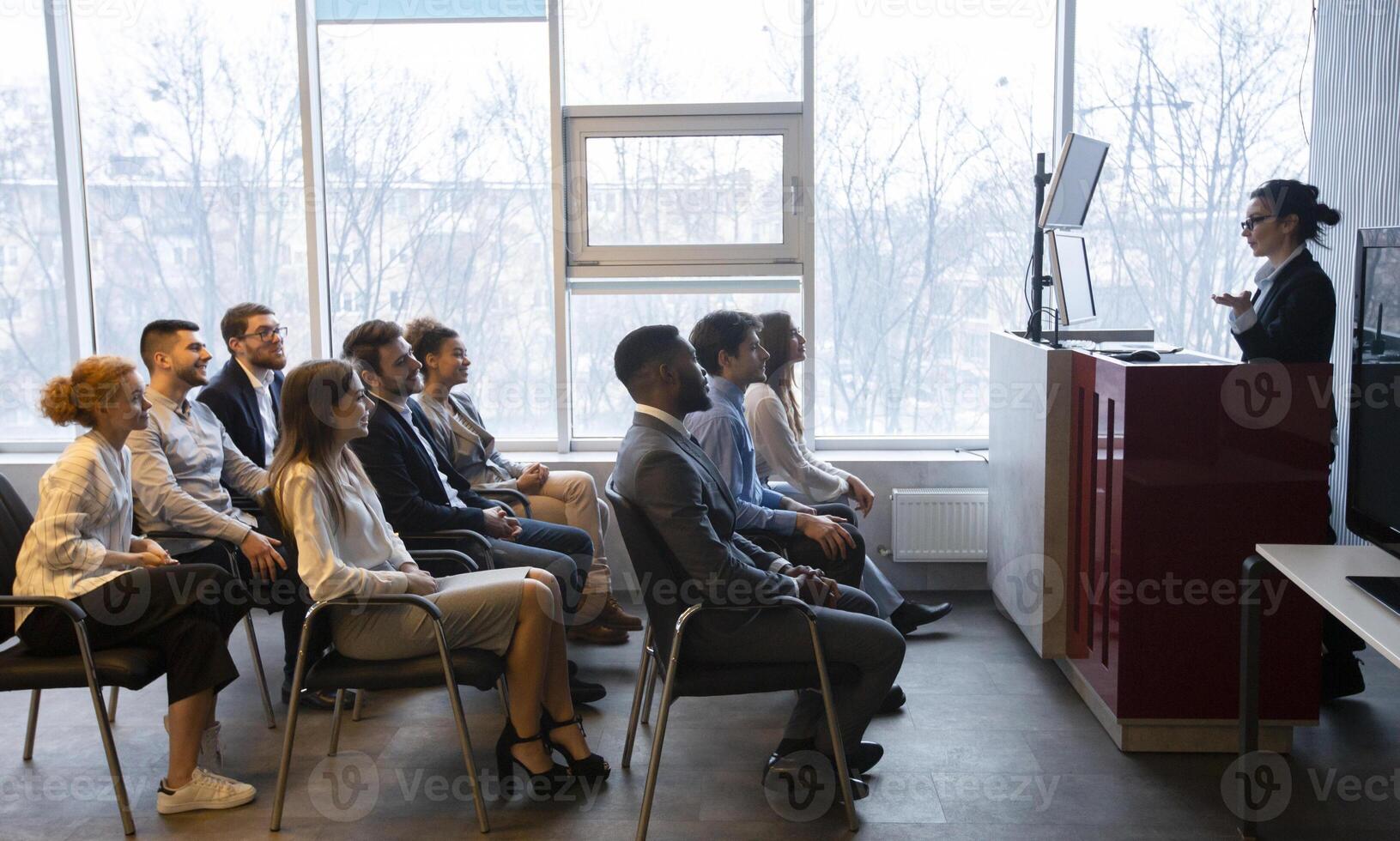 Corporate training concept. Business coach giving presentation to young staff at conference room, side view photo