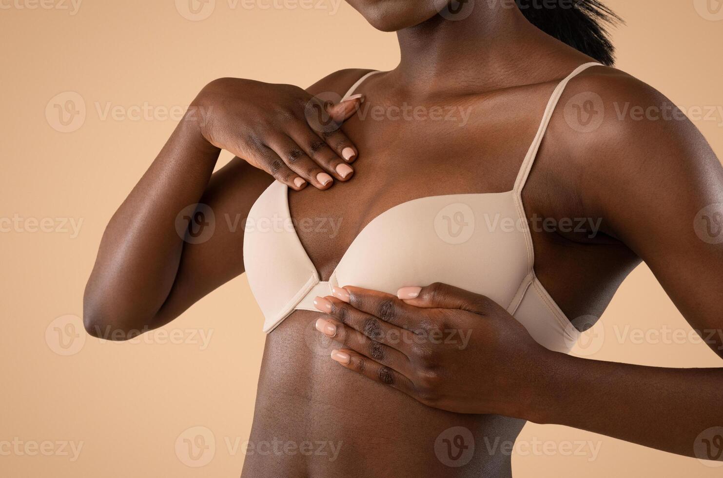 Breast self-screening concept. Cropped of young african american woman in beige bra examining her breasts for cancer prevention, closeup, beige studio background, copy space photo
