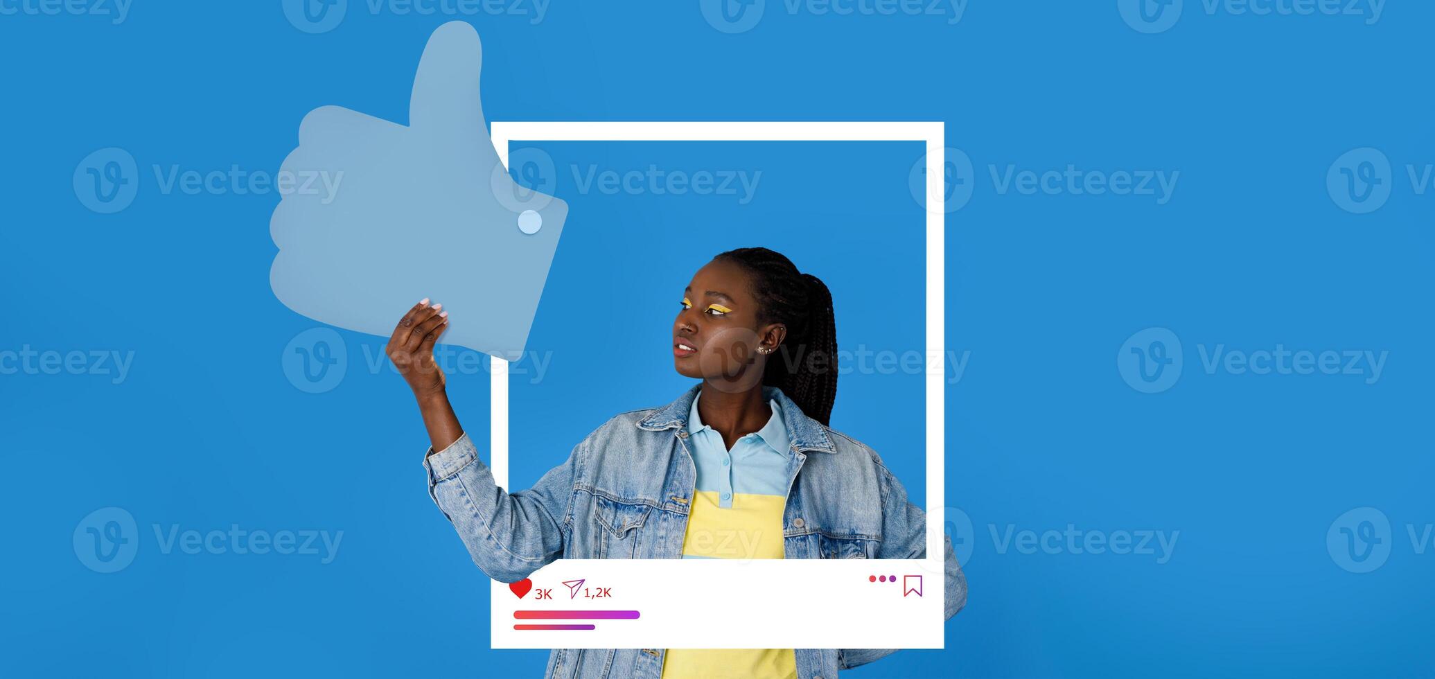 A young influencer gives a thumbs up while holding a large like symbol. She stands in front of a bright blue background, showcasing her connection to social media and blogging. photo
