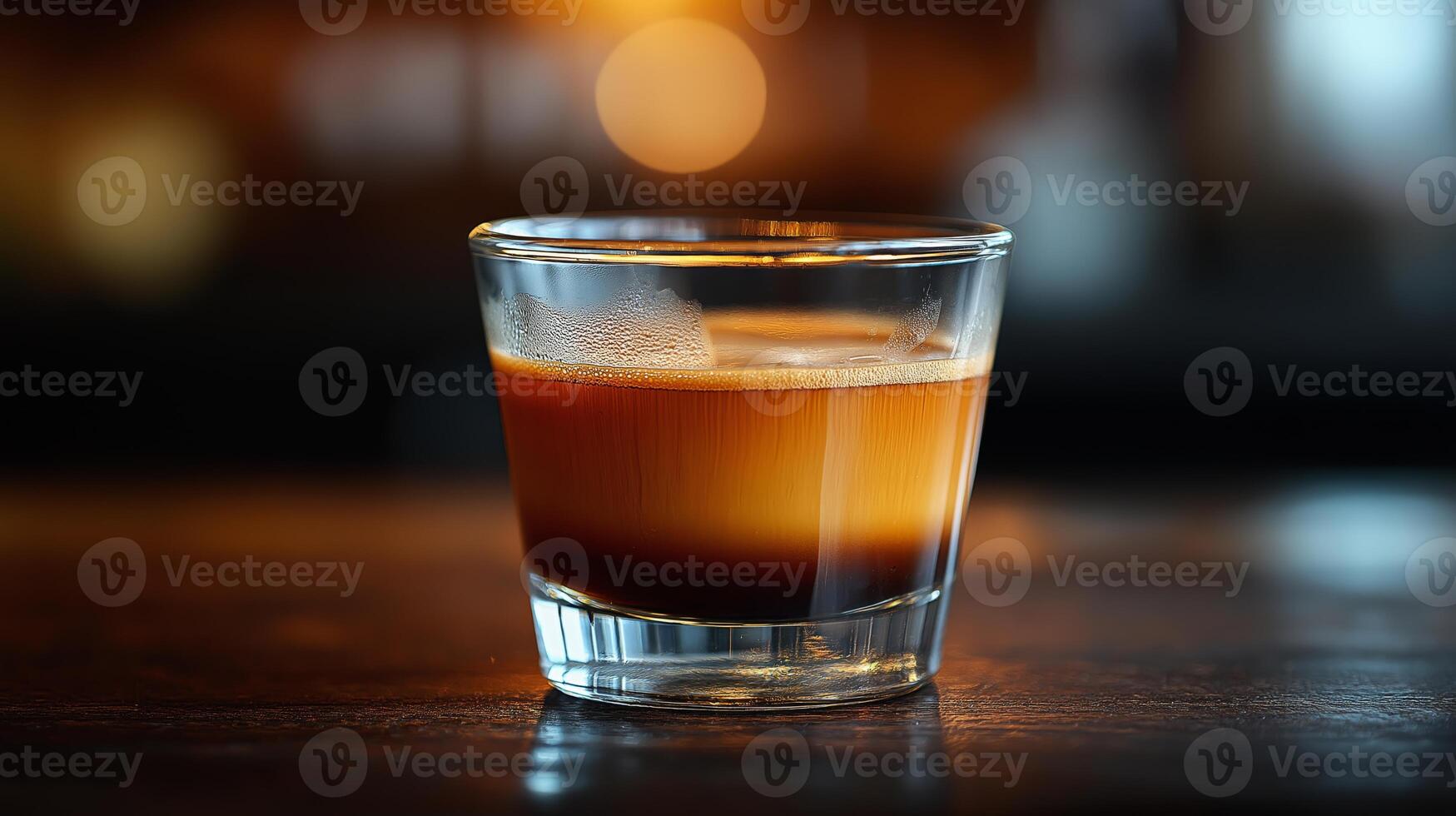 Hot espresso in a clear glass, highlighting rich tones against a softly lit background. photo