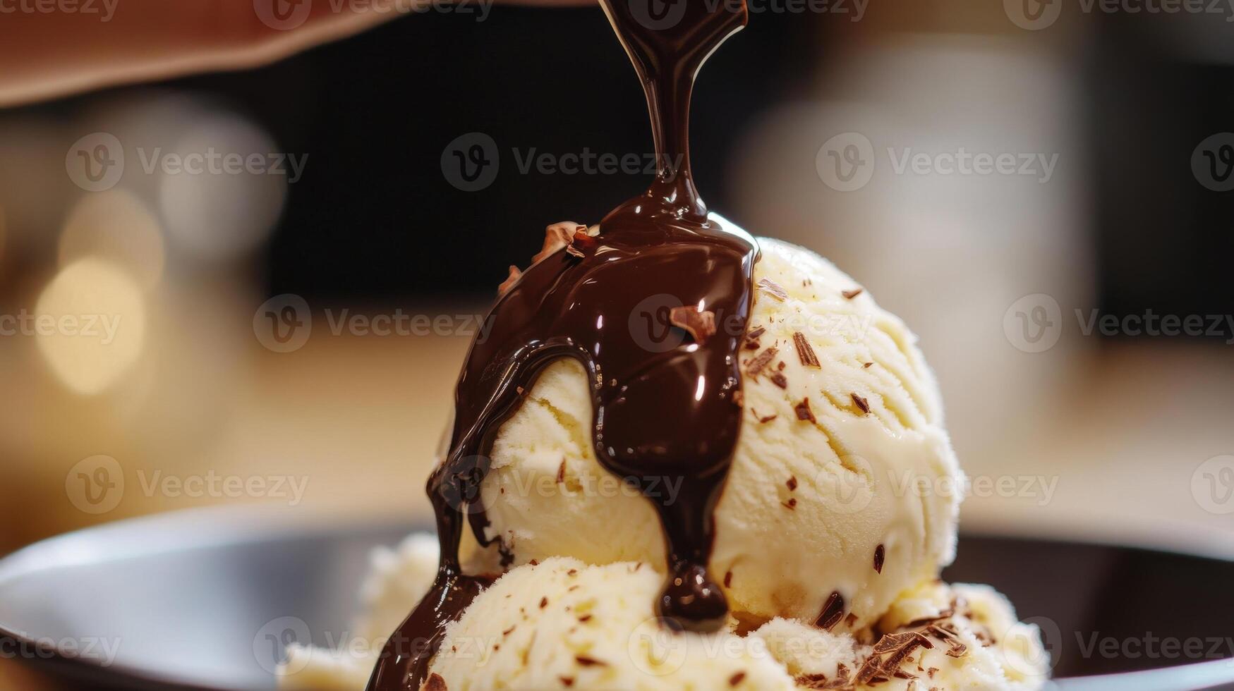 Close-up view of a scoop of vanilla ice cream topped with melted chocolate sauce. photo