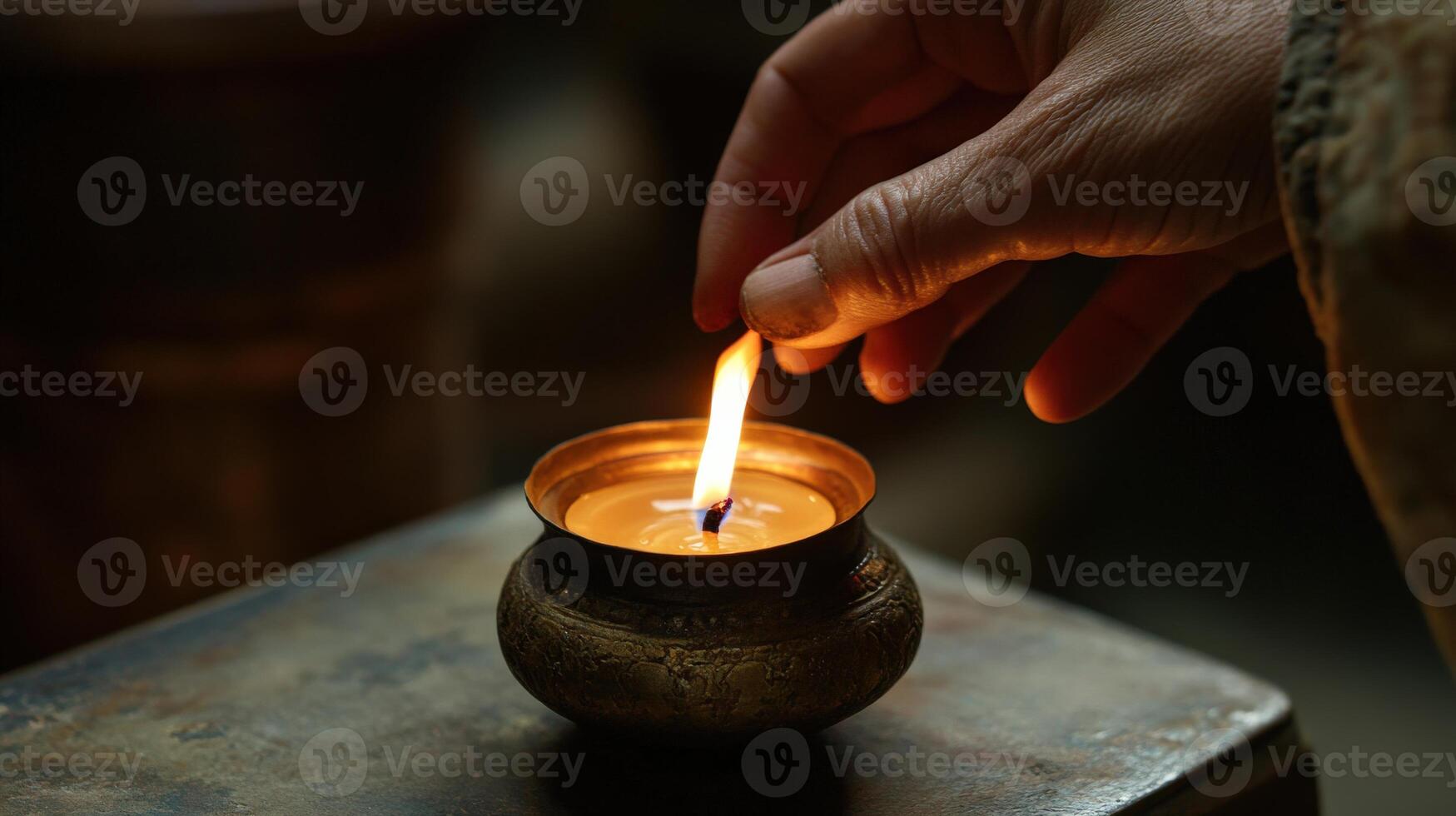 Close-up view of hand lighting a small candle. photo