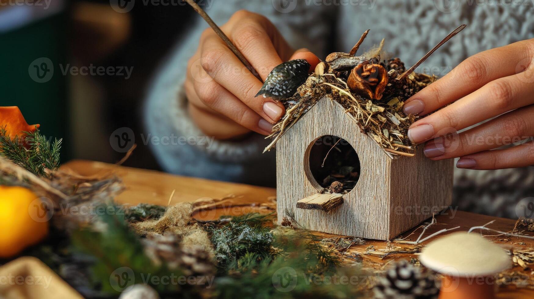 Closeup view of hands constructing a decorative birdhouse. photo