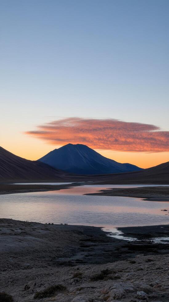 Sunset over Volcanic Lake in Andes Mountains, Chile. Breathtaking landscape panorama, serene and majestic nature scenery at dawn. Peaceful reflection of vibrant colors in the still water. photo