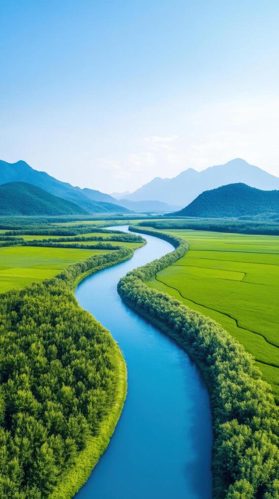 Serene River Landscape Breathtaking View of a Winding River Flowing Through Lush Green Fields and Majestic Mountains. A Perfect Summer Vacation Destination Image photo