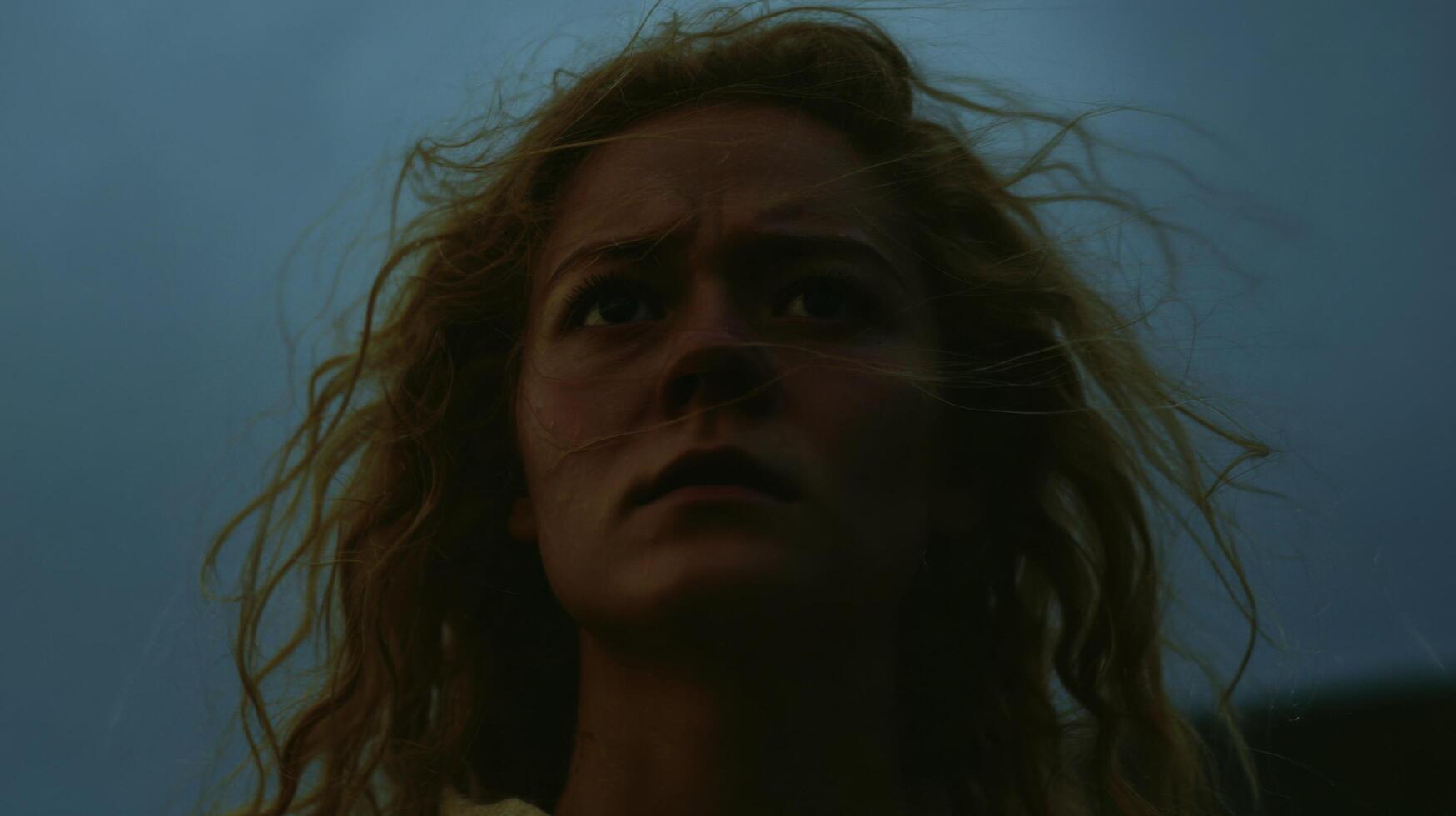 A Pensive Gaze A Dramatic Portrait of a Young Woman with Windblown Hair, Contemplating the Unknown. Her Expression is Thoughtful a photo