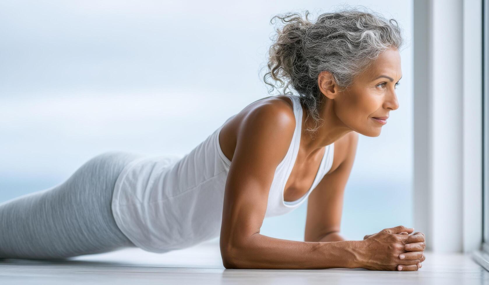 A Focused Mature Woman Performing Plank Exercise, Embracing a Healthy Lifestyle, Promoting Strength, Wellness, and Inner Peace. Di photo