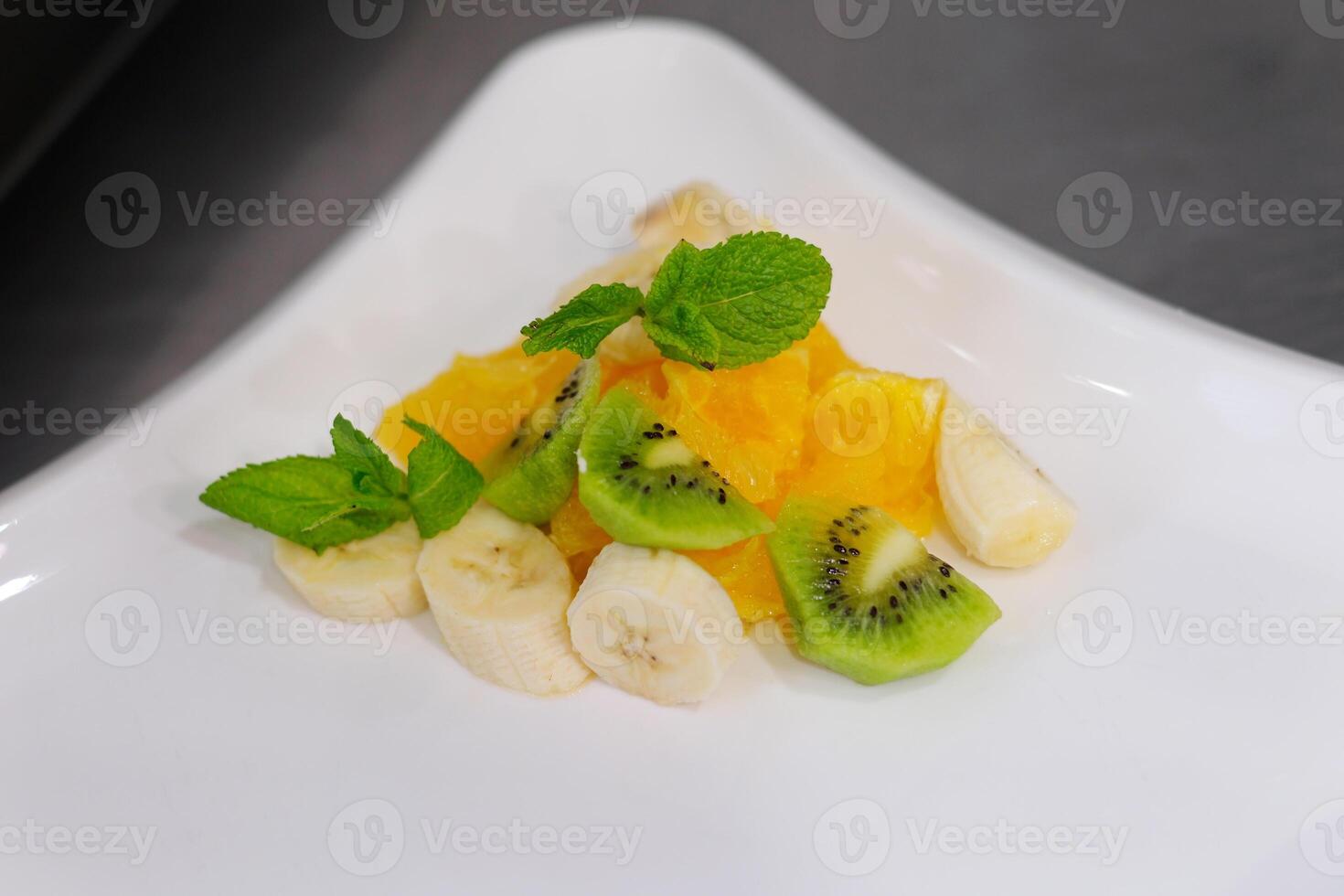 fruit salad kiwi banana orange White bowl of fresh fruit salad isolated on white background. Healthy summer meal photo