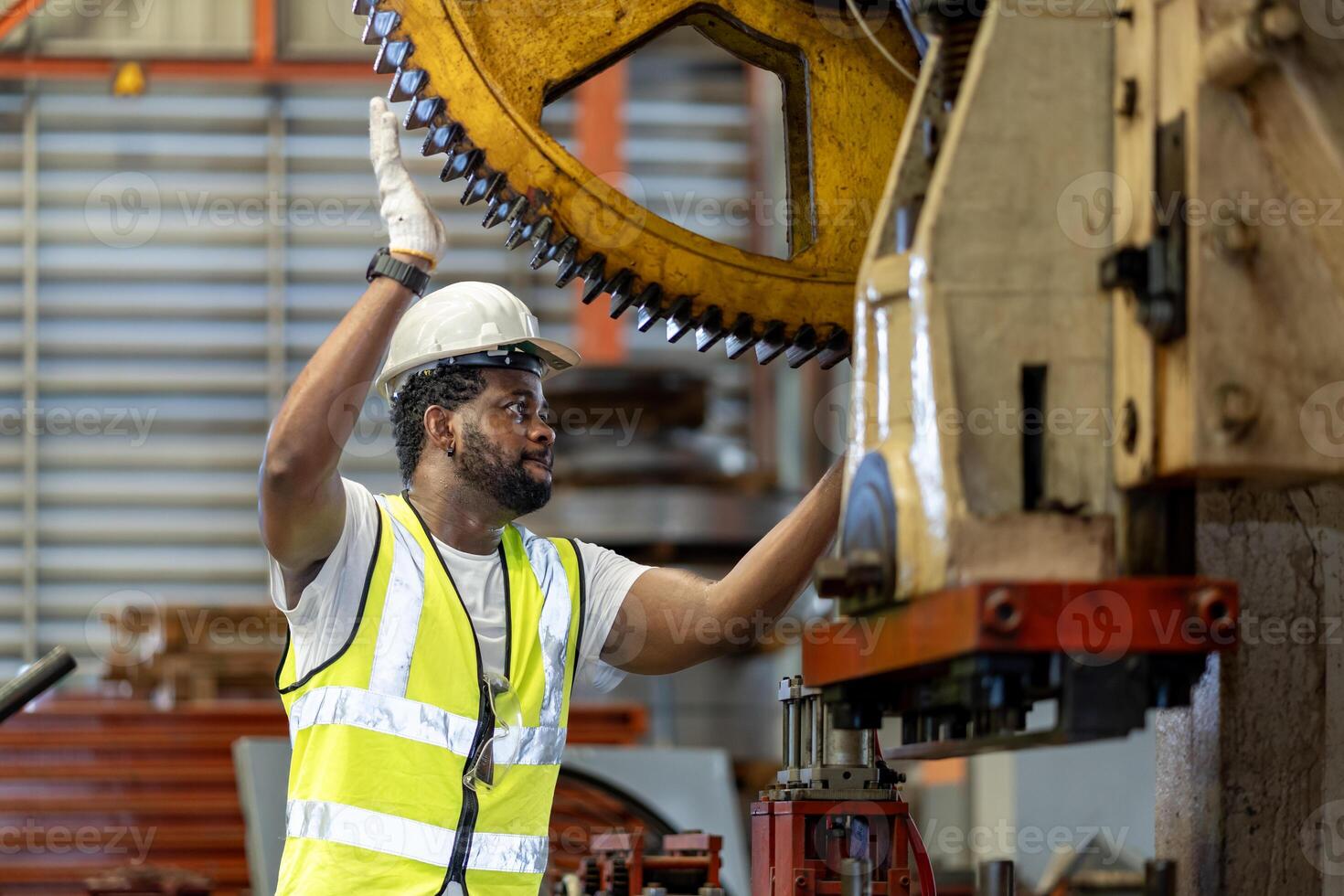 African American mechanic worker is checking gear for hydraulic machine inside metal steel manufacturing factory for maintenance and inspection concept photo