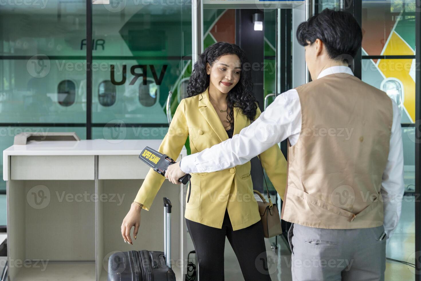 Airline ground staff is using metal scanner for security check every passenger in the airport departure terminal for safety protocol before boarding in the plane photo