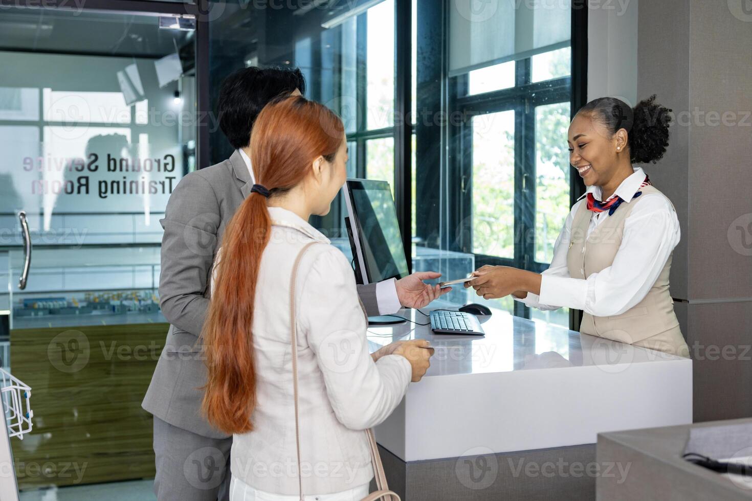 Couple passengers are getting their boarding pass from airline ground crew at departure gate into the airplane for final inspection before boarding into the plane photo