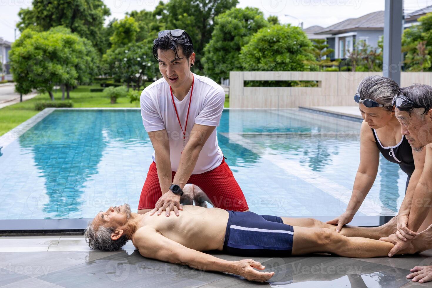 Life guard is doing CPR to drowning asian senior man at sport club with the family support for accident and emergency medical procedure service and life insurance photo