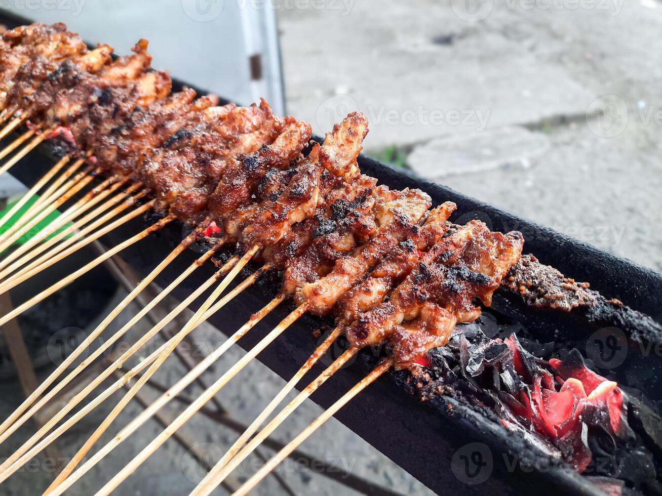 Madura Chicken Satay Being Grilled Over Charcoal photo