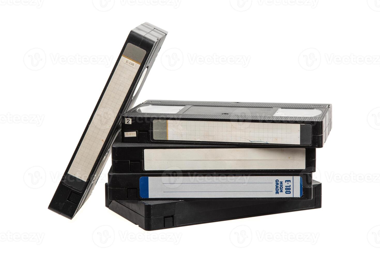 Stack of old VHS tapes with handwritten labels and visible wear, arranged casually on white back photo
