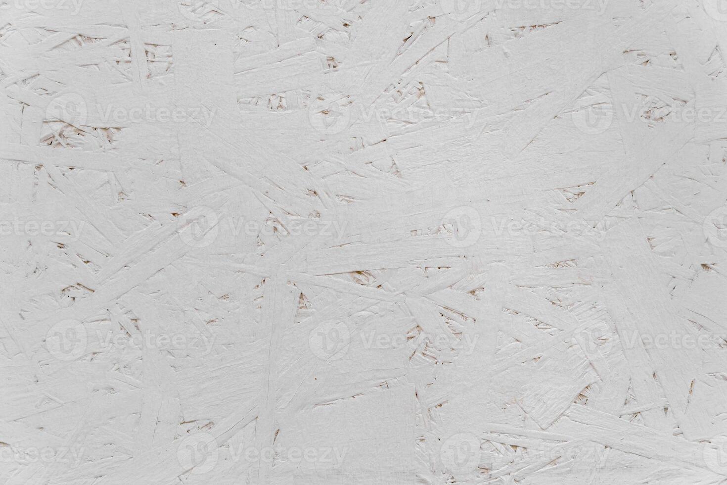 The uneven surface is neatly painted with white paint. White construction background. photo