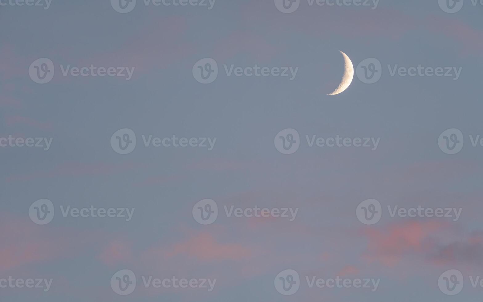 A crescent moon is seen in the sky photo