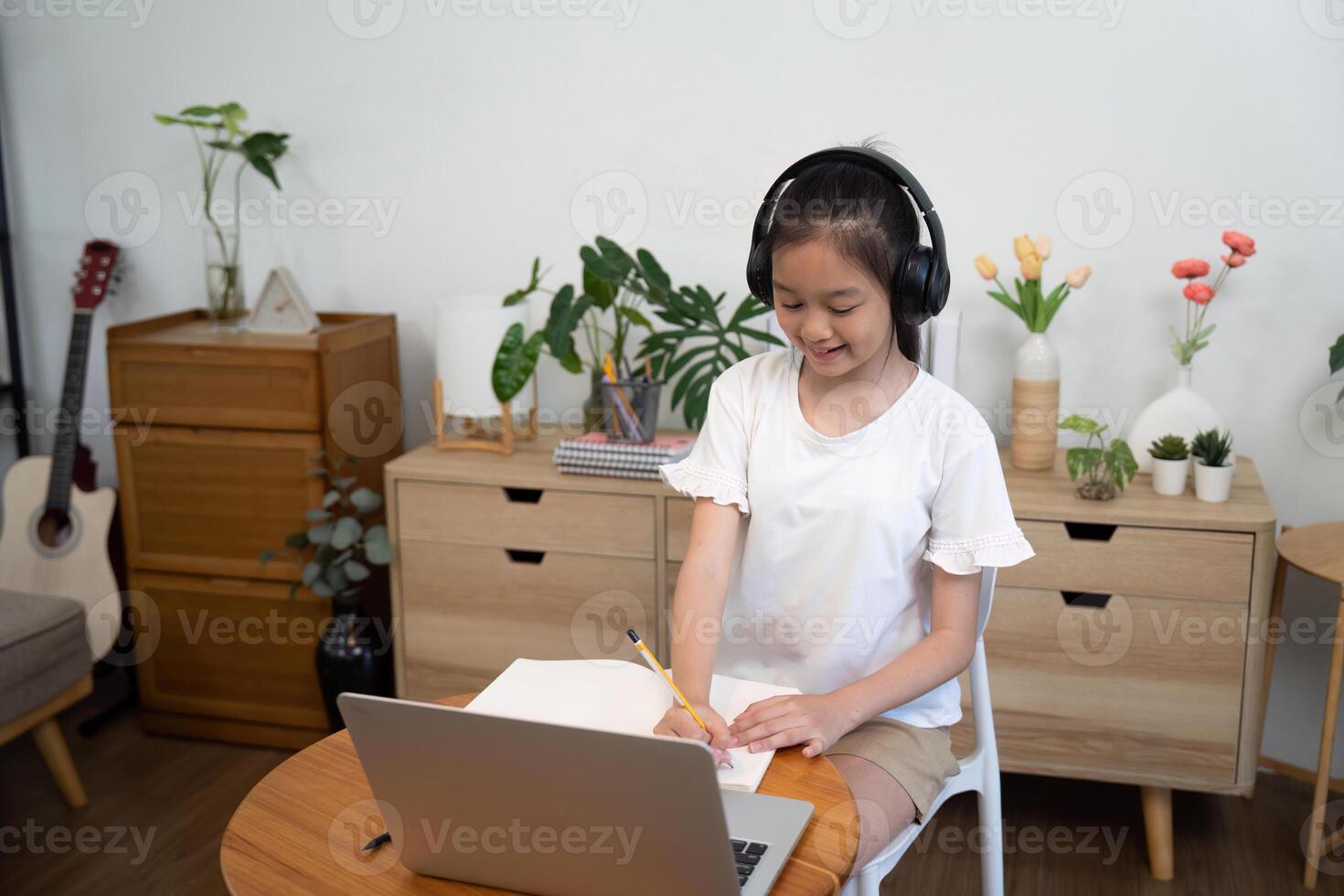 Back to School focused girl studying with headphones and laptop photo