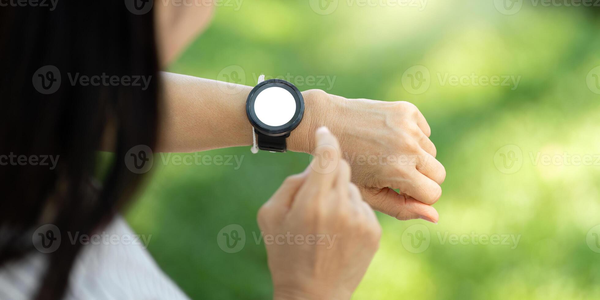 Wellness engagement with elderly woman using fitness watch in nature photo
