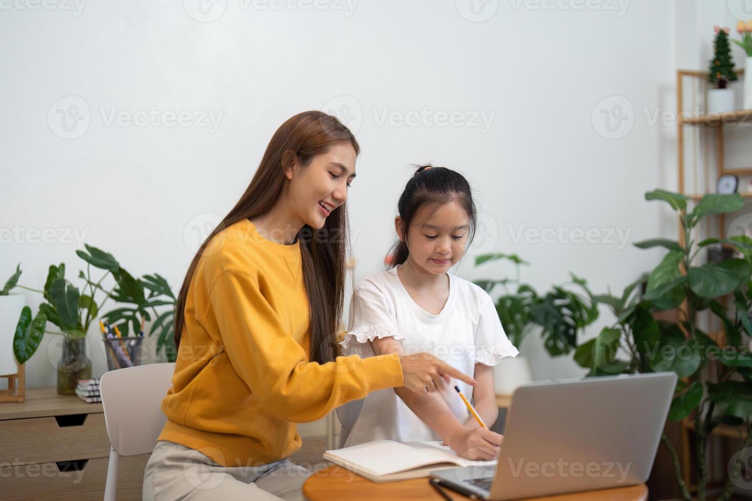 Back to school guidance with mother teaching daughter on a laptop photo