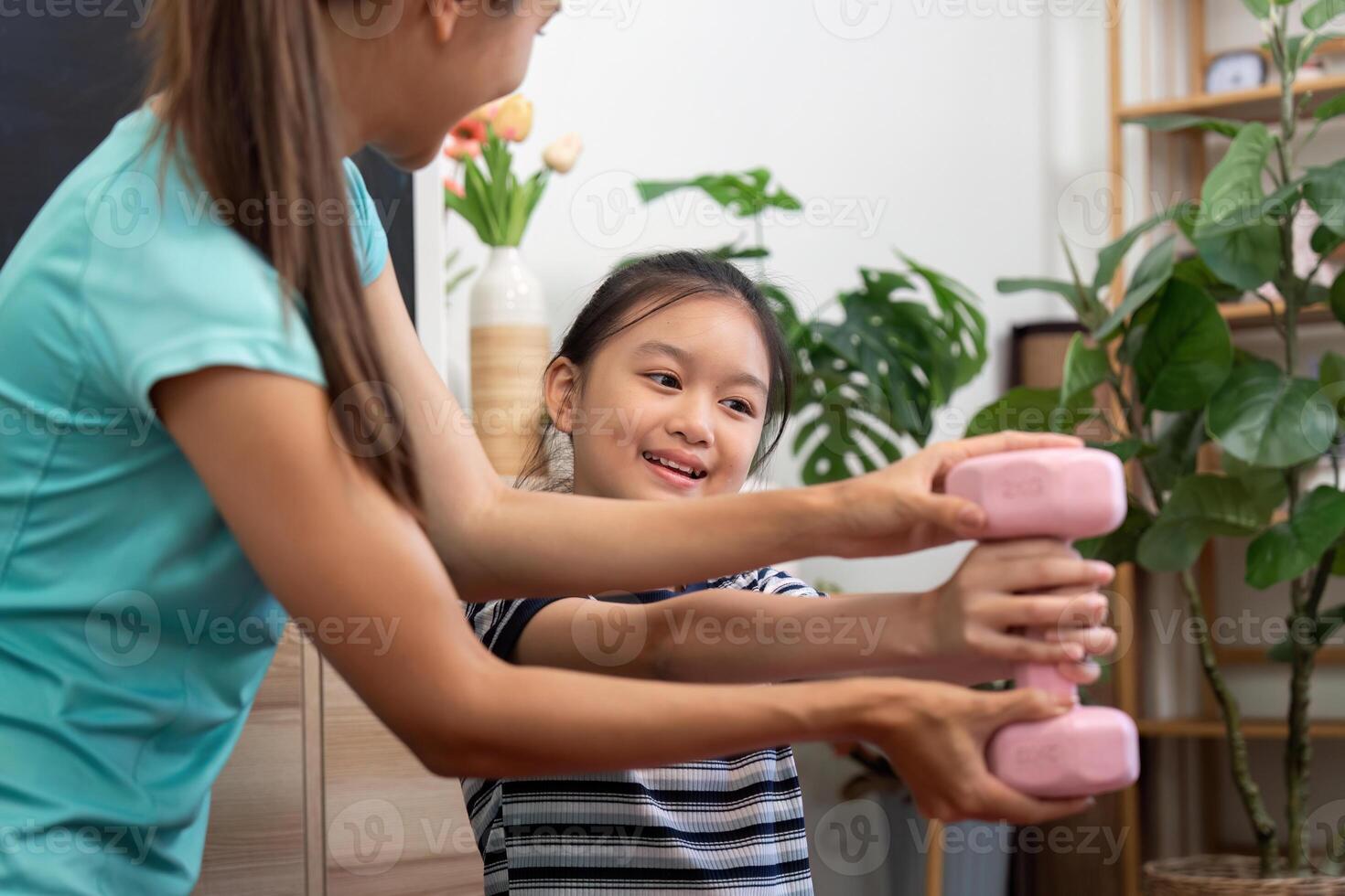 Wellness yoga session for mother and daughter with pink dumbbells photo
