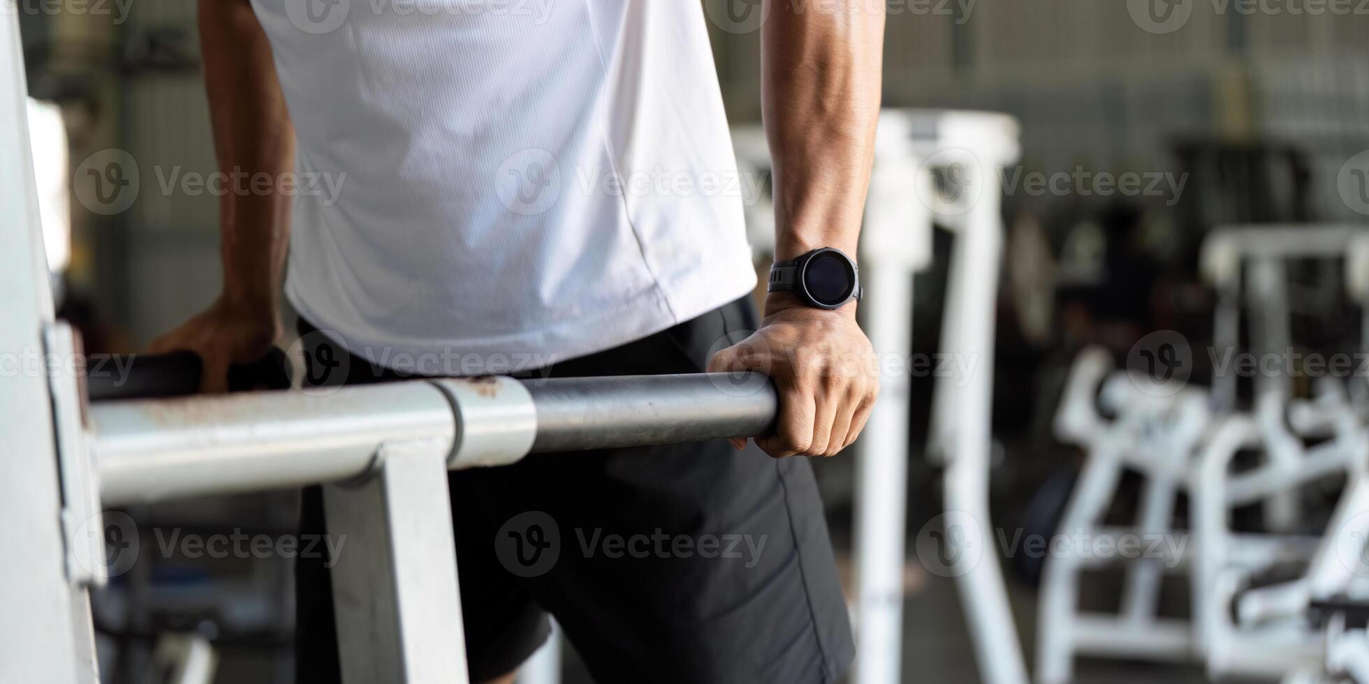 Wellness and Fitness. Young man performing dips in gym for upper body strength. photo