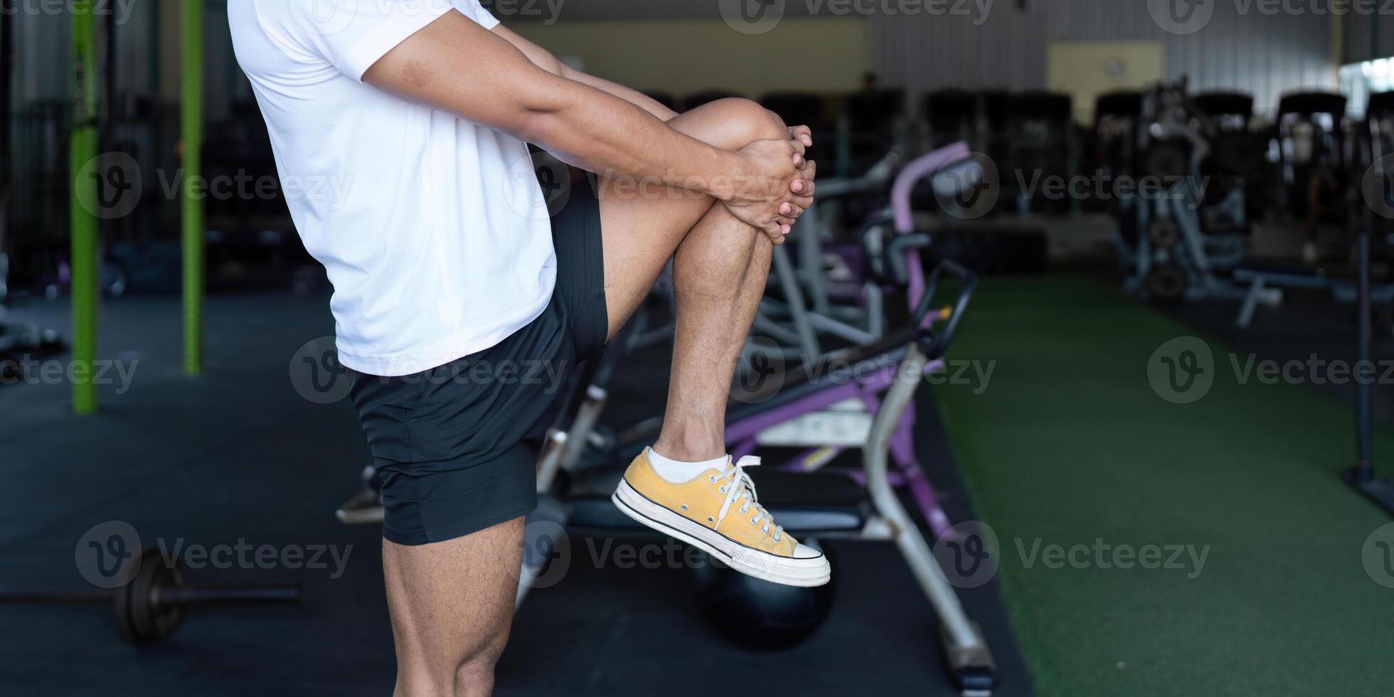 Wellness and Strength. Young man performing a knee lift exercise in a gym. photo