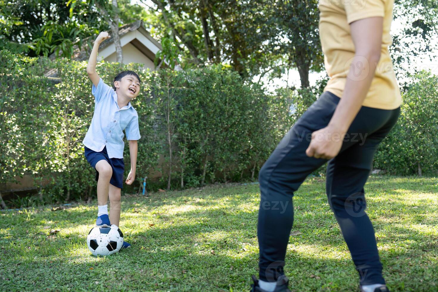Activity. Young Boy Having Fun Kicking a Soccer Ball with Dad photo