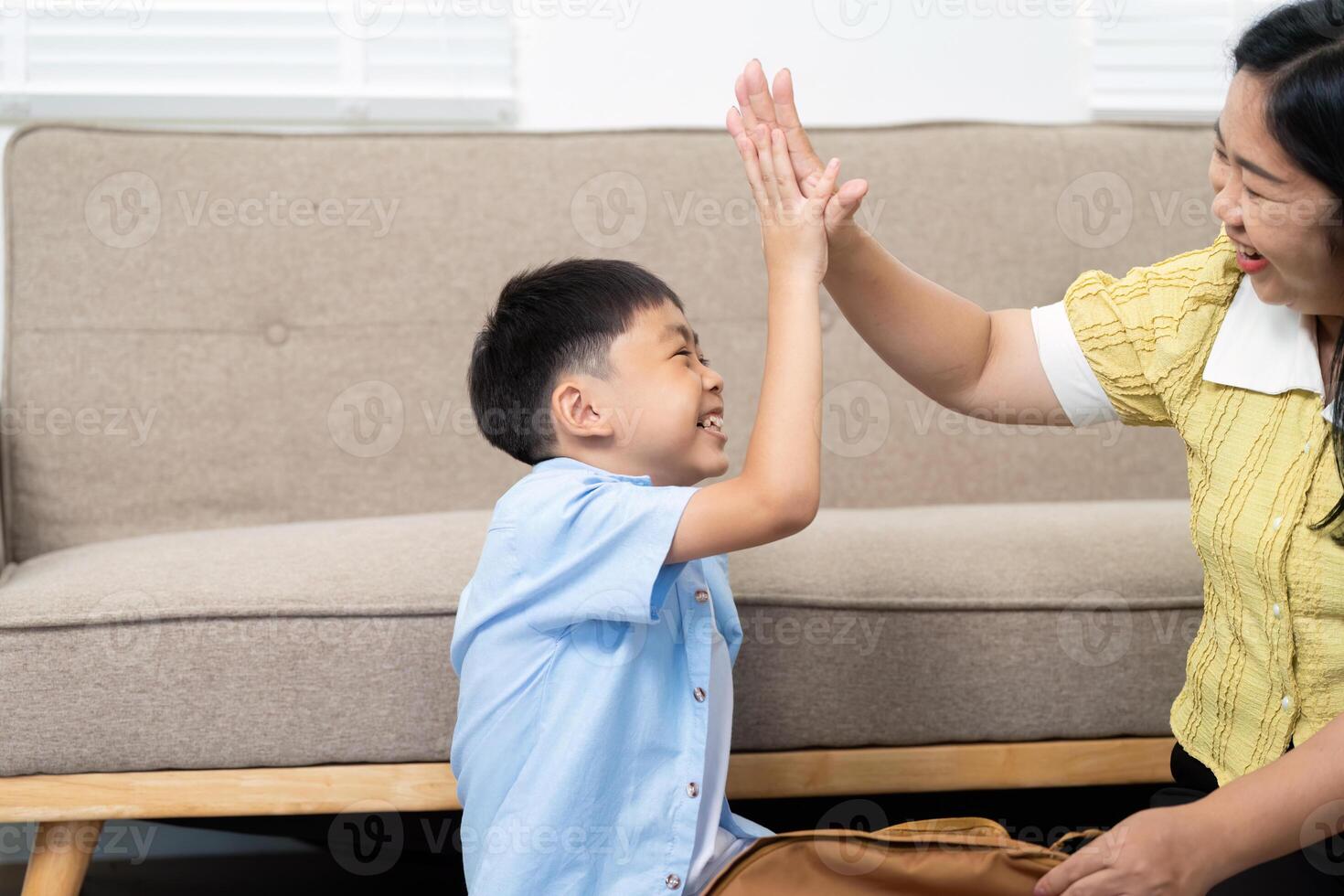 Back to School. Child and mother sharing a high-five at home. photo
