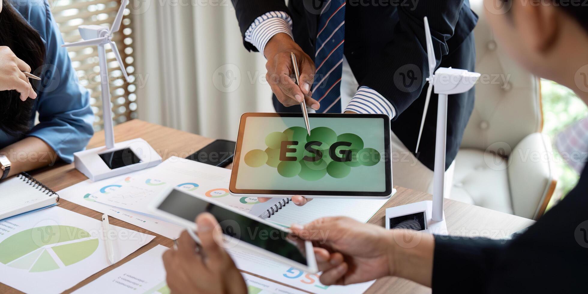 Sustainability and ESG. Professionals presenting ESG concepts on a tablet during a meeting. photo
