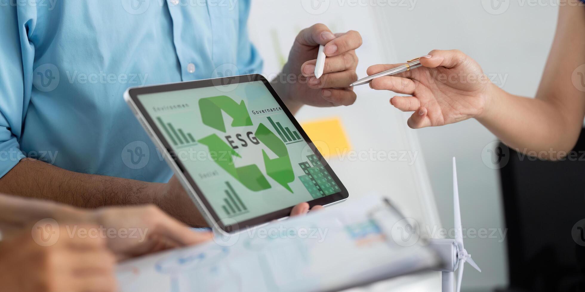ESG and Sustainability. Professionals discussing ESG strategies with digital tools in a modern office. photo