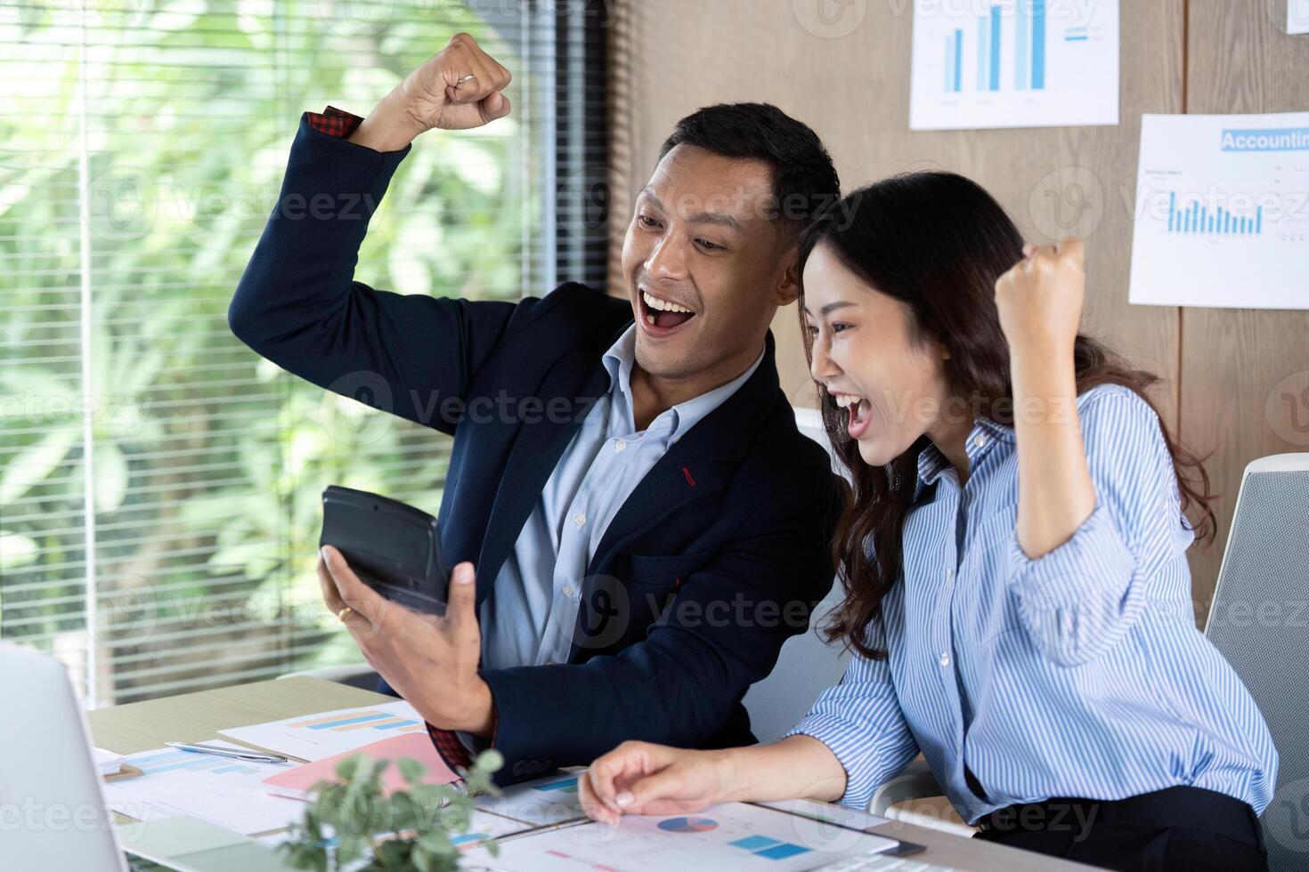 Celebrating Success in Business. Professionals excitedly viewing results on a tablet. photo