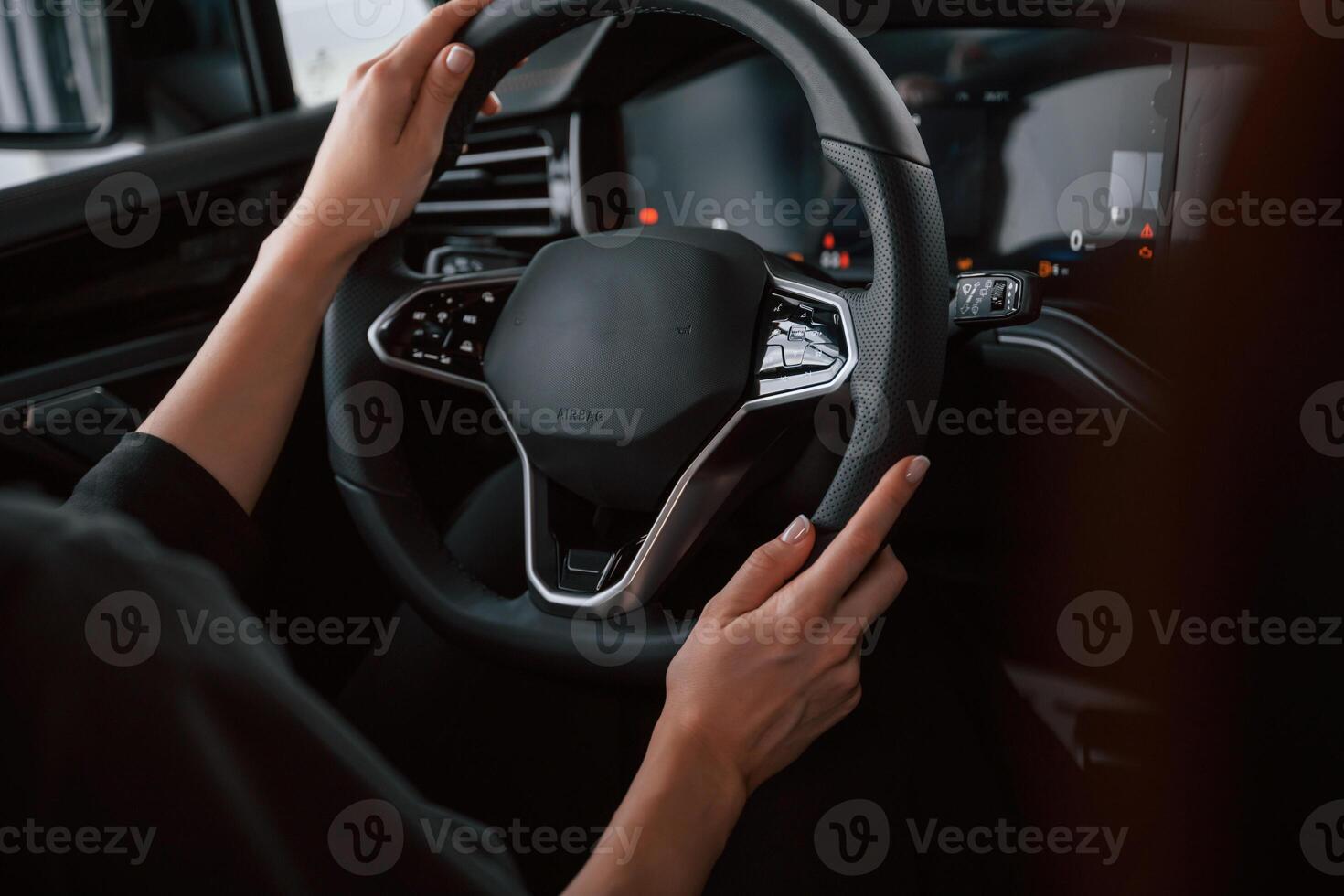 Focused close up view of woman hands that are driving new car. photo