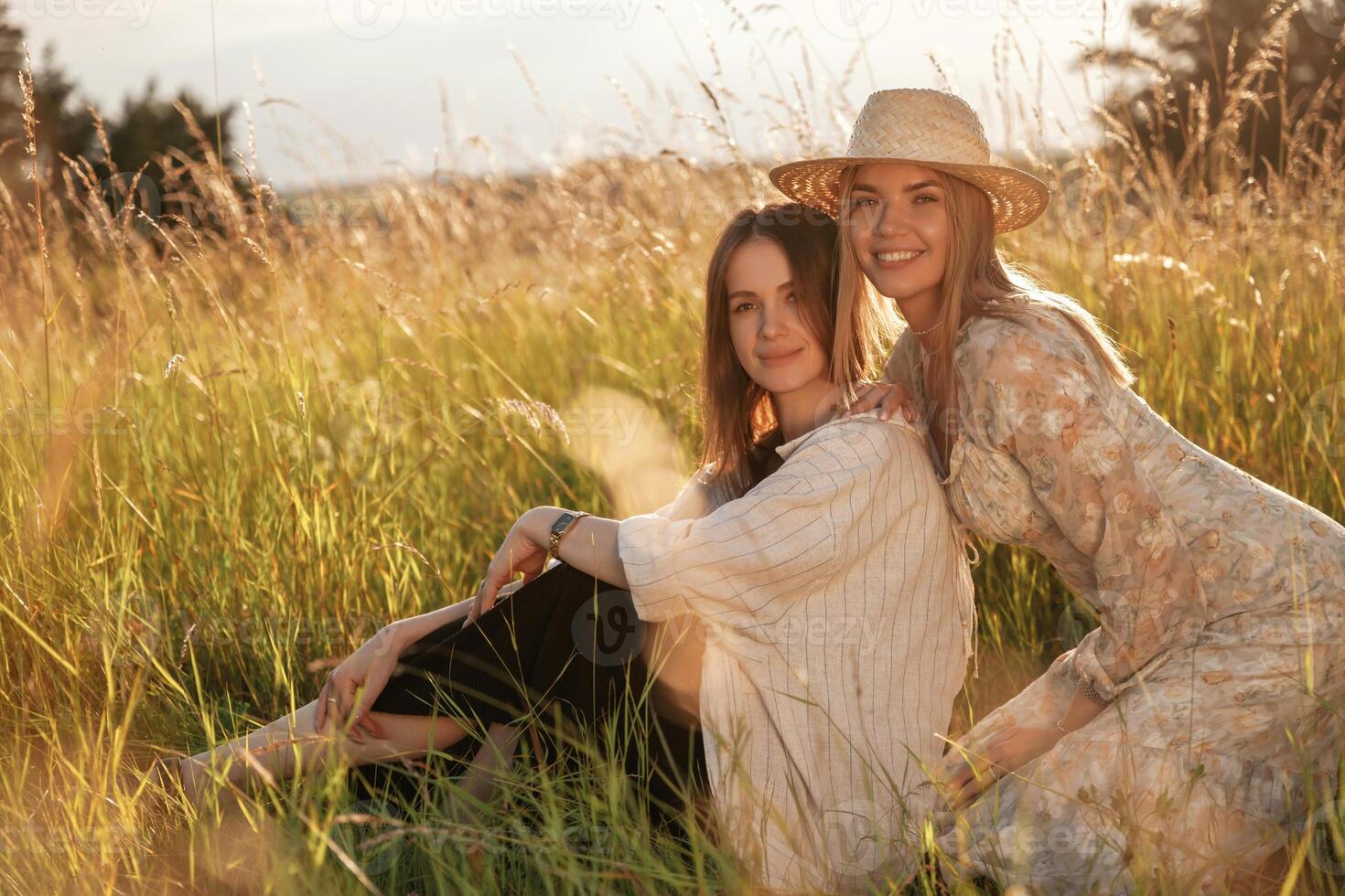 Sitting together. Two ,,women friends are in the rural field photo